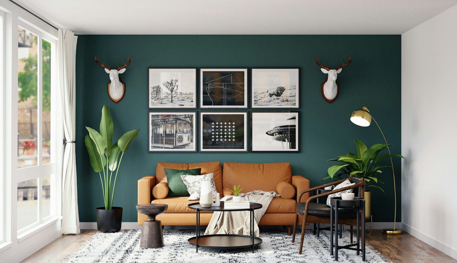An orange sofa against a deep green wall, hung with framed prints